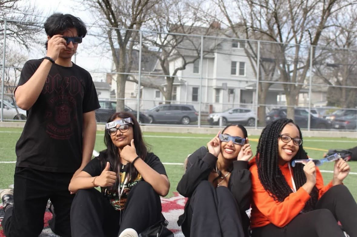 high school students wearing eclipse glasses outside