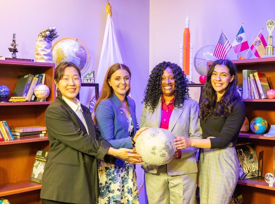 four NASA scientists and educators pose with a moon prop at the U.S. Department of Education office